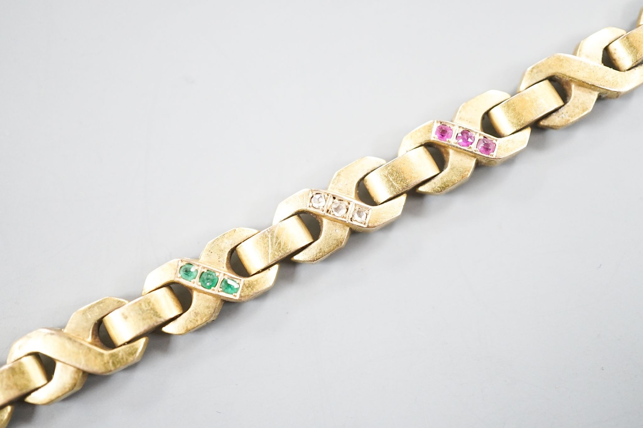 A modern continental yellow, metal, ruby, emerald and diamond set bracelet, 18.3cm, gross weight 14.5 grams.